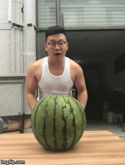 A Man In A White Tank Top Is Holding A Large Watermelon On A Table GIF