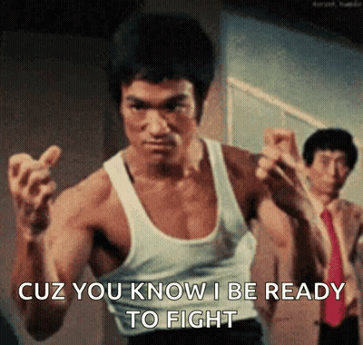 A Man In A White Tank Top Is Ready To Fight . GIF