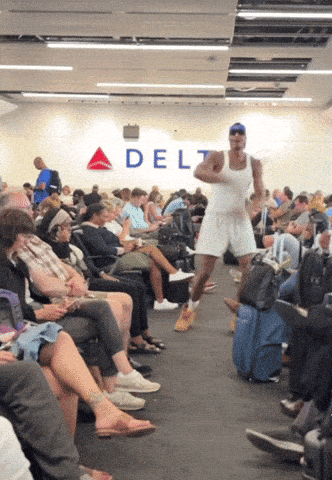 A Man In A White Tank Top Is Running In Front Of A Delta Sign GIF