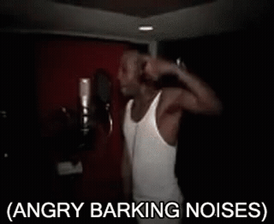 A Man In A White Tank Top Is Singing Into A Microphone With The Words Angry Barking Noises Below Him GIF