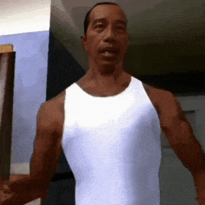 A Man In A White Tank Top Is Standing In Front Of A Wall GIF