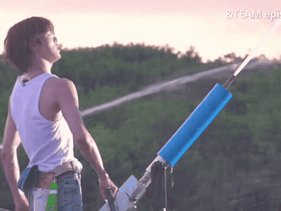 A Man In A White Tank Top Is Standing In Front Of A Water Cannon With The Words & Team Epi On The Bottom Right GIF