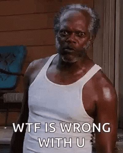 A Man In A White Tank Top Is Standing In Front Of A Window . GIF