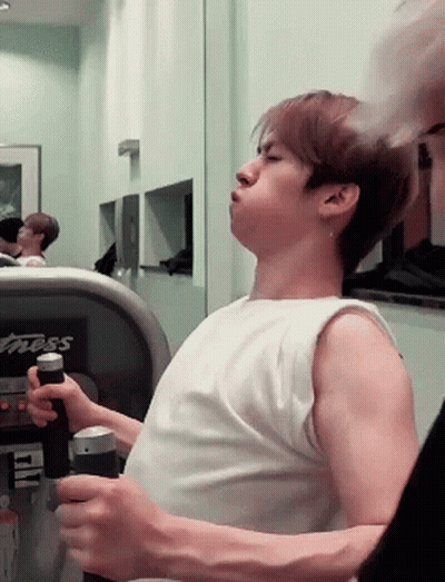 A Man In A White Tank Top Is Using A Treadmill That Says Fitness On It GIF