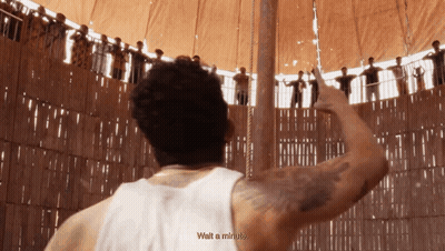 A Man In A White Tank Top Says Wait A Minute In Front Of A Crowd GIF