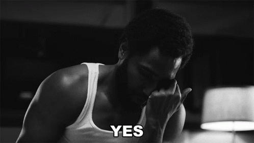 A Man In A White Tank Top Says Yes In A Black And White Photo GIF