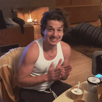 A Man In A White Tank Top Sits At A Table With A Bowl Of Ice Cream GIF