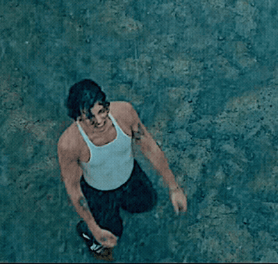 A Man In A White Tank Top With His Arms Outstretched Screams GIF