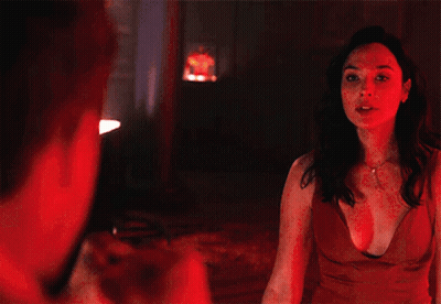 A Man In A White Tuxedo And Bow Tie Is Standing In A Dark Room GIF