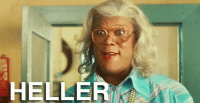 A Man In A Wig And Glasses Is Standing In Front Of A Door And The Word Heller Is On The Bottom GIF