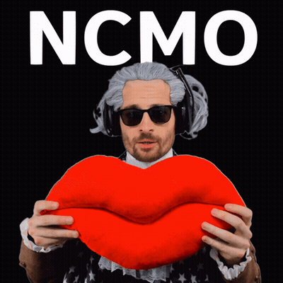 A Man In A Wig And Sunglasses Is Holding A Red Heart With The Word Ncmo On The Bottom GIF