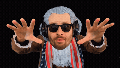 A Man In A Wig And Sunglasses Is Wearing Headphones And An American Flag Jacket GIF
