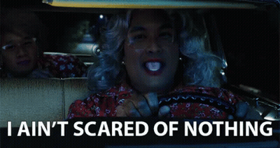 A Man In A Wig Is Driving A Car With The Words " I Ain T Scared Of Nothing " Below Him GIF
