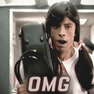 A Man In A Wig Is Holding A Violin Case And The Word Omg Is Behind Him GIF