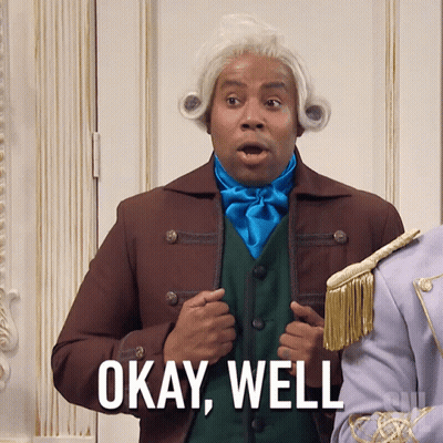 A Man In A Wig Says Okay Well In Front Of A Door GIF