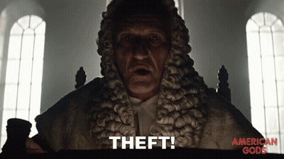 A Man In A Wig Says " Theft " In Front Of An American Gods Poster GIF