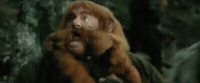 A Man In A Wizard Hat Is Holding A Stick In A Field GIF