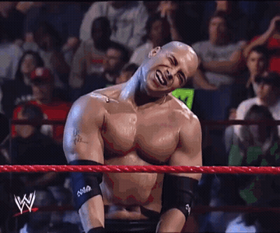 A Man In A Wrestling Ring Has A W On His Arm Band GIF