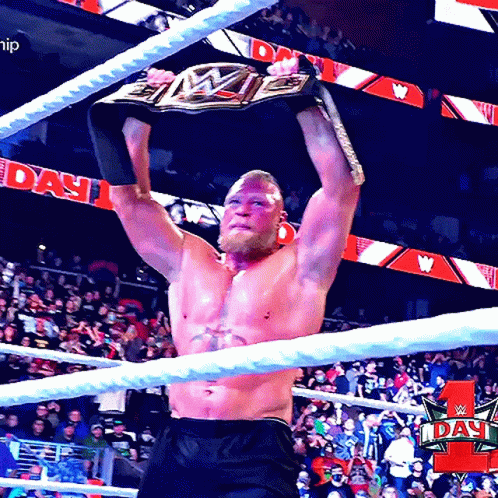 A Man In A Wrestling Ring Holds A Wwe Championship Belt Above His Head GIF