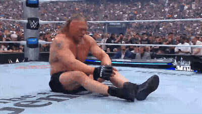 A Man In A Wrestling Ring Is Wearing A Pair Of Black Gloves With The Letter L On The Side GIF