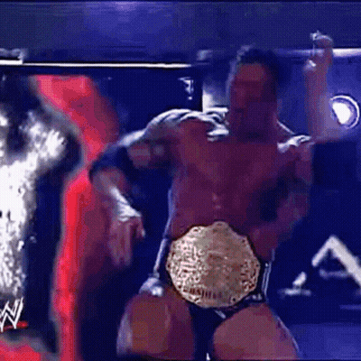 A Man In A Wrestling Ring Is Wearing A World Heavyweight Championship Belt .. GIF