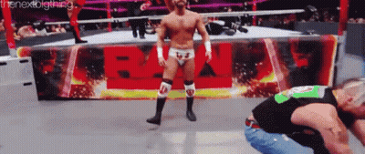 A Man In A Wrestling Ring Stands In Front Of A Sign That Says ' Wwe ' GIF
