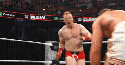 A Man In A Wrestling Ring With A Banner That Says Raw On It GIF