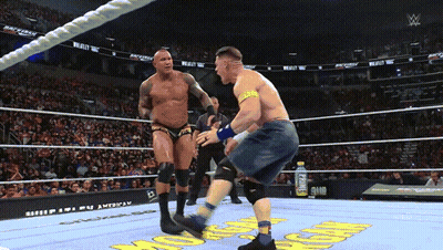 A Man In A Wrestling Ring With A Gatorade Bottle Behind Him GIF