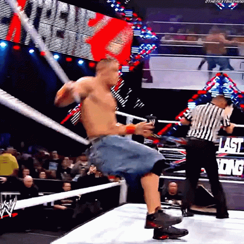 A Man In A Wrestling Ring With A Referee And A Sign That Says Last King On It GIF