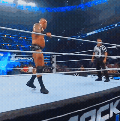 A Man In A Wrestling Ring With A Referee And A Sign That Says Smack GIF
