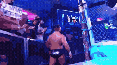 A Man In A Wrestling Ring With A Sign That Says Nnw Wrestling In The Background GIF