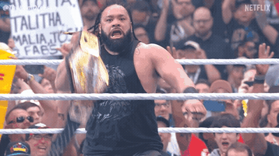 A Man In A Wrestling Ring With A Sign That Says ' Talitha ' On It GIF