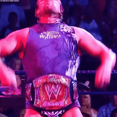 A Man In A Wrestling Ring With A W Belt Around His Waist .. GIF