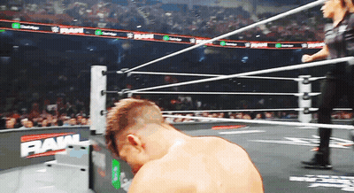 A Man In A Wrestling Ring With The Word Raw On The Wall GIF