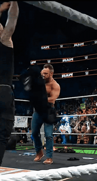 A Man In A Wrestling Ring With The Words Raw On The Walls GIF