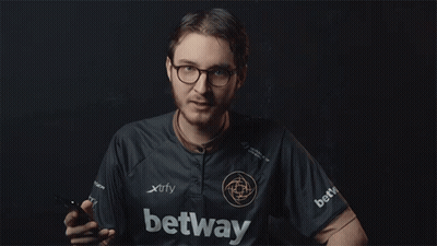 A Man In A Xtrfy Shirt Is Holding A Cell Phone GIF