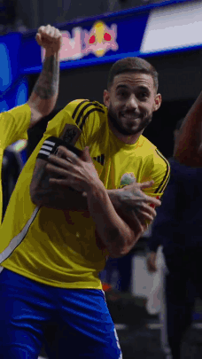 A Man In A Yellow Adidas Shirt Is Holding A Trophy GIF