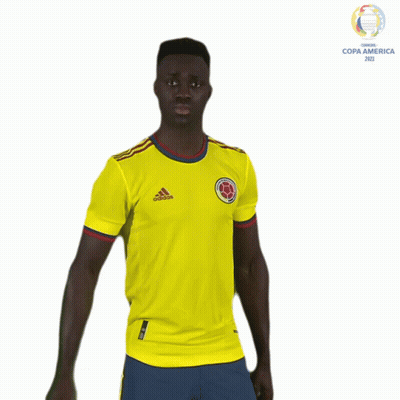 A Man In A Yellow Adidas Shirt Stands In Front Of A Copa America Logo GIF