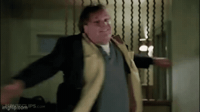 A Man In A Yellow Coat Is Dancing In A Room . GIF