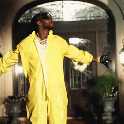 A Man In A Yellow Hazmat Suit Is Standing In Front Of A Door GIF