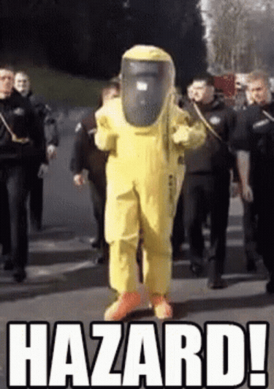 A Man In A Yellow Hazmat Suit Is Walking Down A Street Surrounded By Police Officers .. GIF