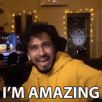 A Man In A Yellow Hoodie With The Words I 'M Amazing On The Bottom GIF