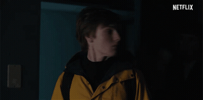 A Man In A Yellow Jacket Is Being Held By Another Man In A Dark Room With Netflix Written In The Corner GIF