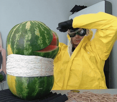 A Man In A Yellow Jacket Is Cutting A Watermelon With A Knife GIF