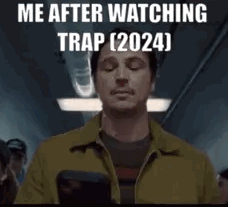 A Man In A Yellow Jacket Is Holding A Cell Phone In His Hand . GIF