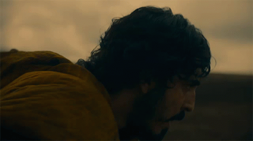 A Man In A Yellow Jacket Is Looking Down GIF