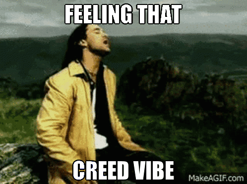 A Man In A Yellow Jacket Is Sitting On A Rock With The Words " Feeling That Creed Vibe " Written Above Him GIF