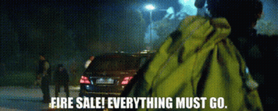 A Man In A Yellow Jacket Stands In Front Of A Car With The Words Fire Sale Everything Must Go GIF