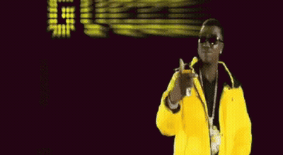 A Man In A Yellow Jacket Stands In Front Of A Sign That Says Dice GIF
