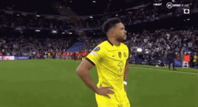 A Man In A Yellow Jersey Is Standing On A Soccer Field . GIF